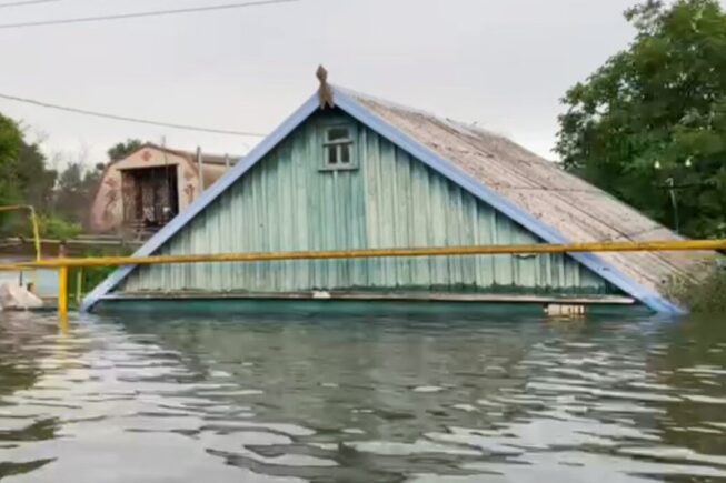 House surrounded by flood water up to roofline