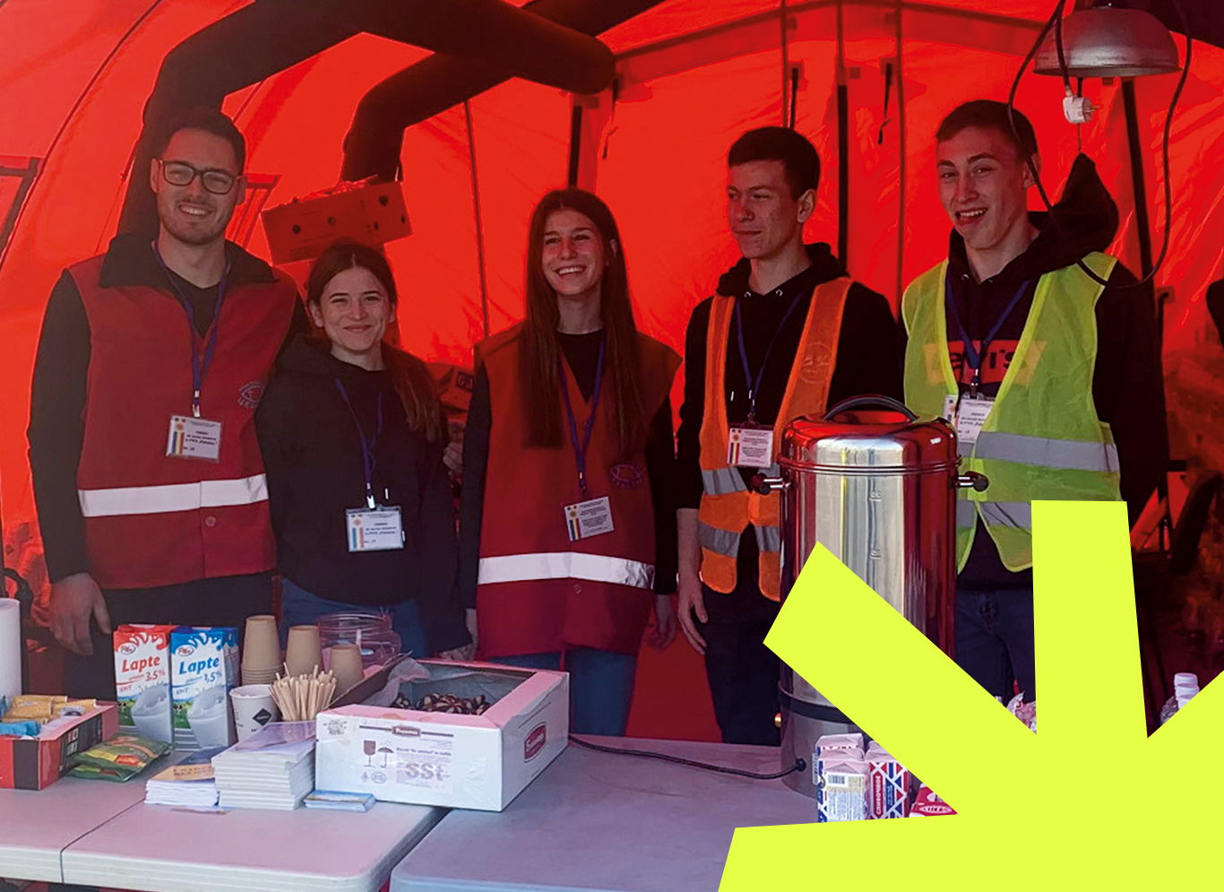 Five people wearing high vis vests in a tent with red background.